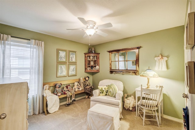 living area with ceiling fan and light colored carpet