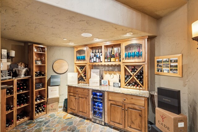 650 Maple Creek Dr, Fairview, TX 75069 - wine cellar with beverage cooler, stone finish flooring, a dry bar, and a textured wall