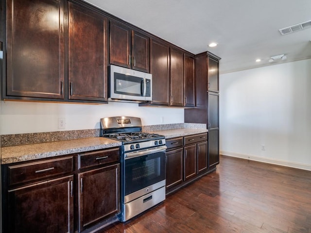 kitchen with stainless steel appliances, dark brown cabinets, and dark hardwood / wood-style floors