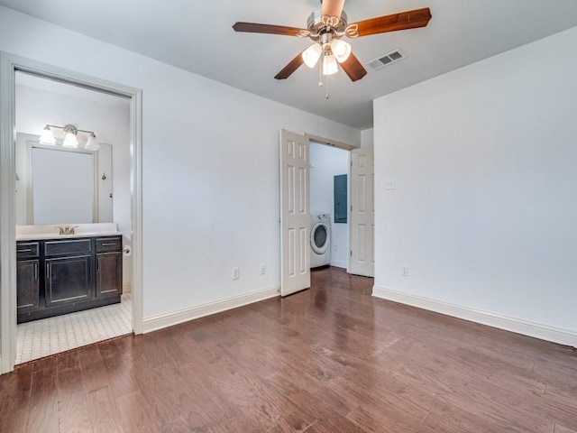 unfurnished bedroom featuring sink, ensuite bath, ceiling fan, dark hardwood / wood-style flooring, and washer / clothes dryer