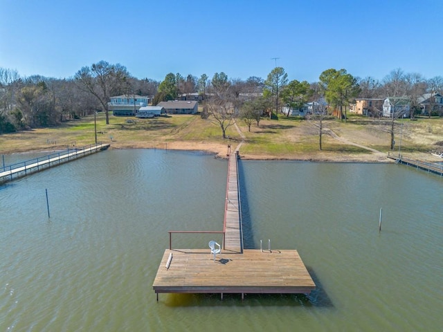 view of dock with a water view and a yard