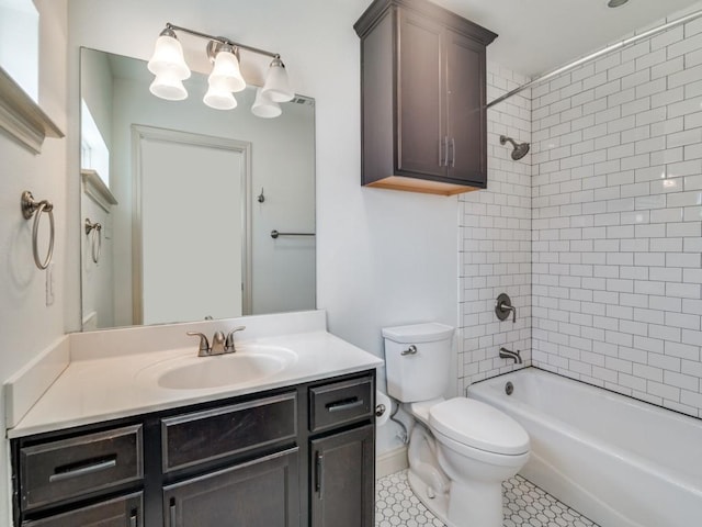 full bathroom with tiled shower / bath, vanity, and toilet