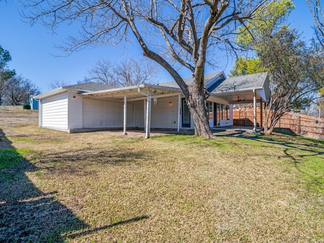 rear view of property featuring a yard and ceiling fan