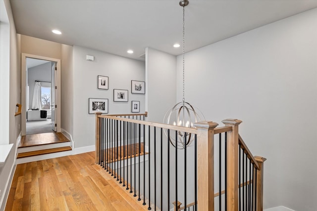 hall with an inviting chandelier and wood-type flooring