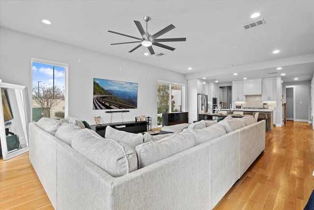 living room with ceiling fan, a healthy amount of sunlight, and light hardwood / wood-style floors