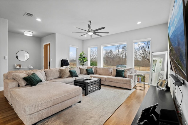 living room featuring hardwood / wood-style flooring, a healthy amount of sunlight, and ceiling fan