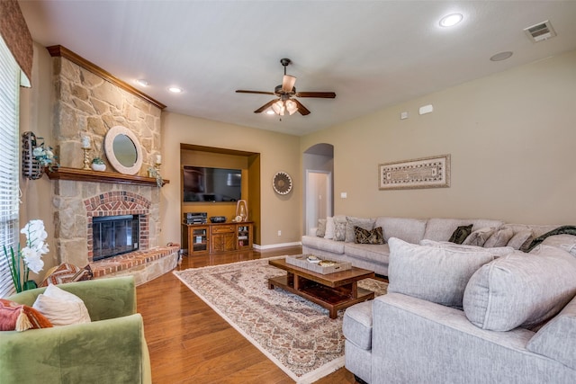 9720 Birdville Way, Fort Worth, TX 76244 - living room with arched walkways, ceiling fan, wood finished floors, a fireplace, and baseboards
