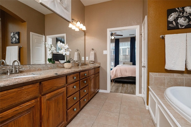 bathroom with ceiling fan, vanity, tile patterned flooring, and a washtub