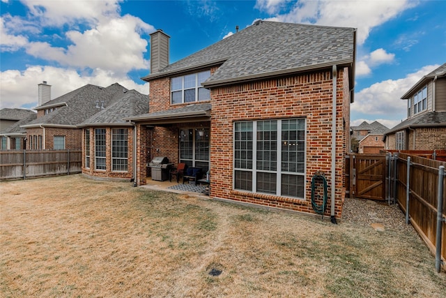 back of house with a patio and a lawn