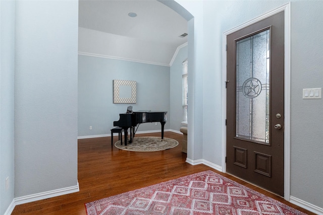 entryway with lofted ceiling, hardwood / wood-style floors, and ornamental molding