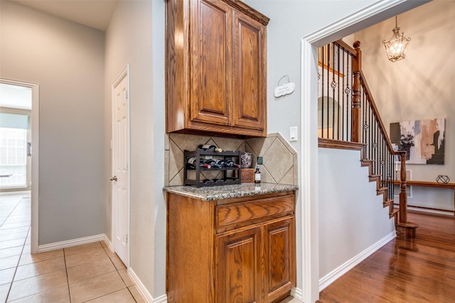 9720 Birdville Way, Fort Worth, TX 76244 - bar featuring tasteful backsplash, a chandelier, stairs, baseboards, and light tile patterned floors