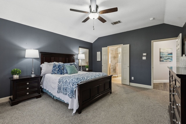 bedroom featuring light carpet, connected bathroom, vaulted ceiling, and ceiling fan