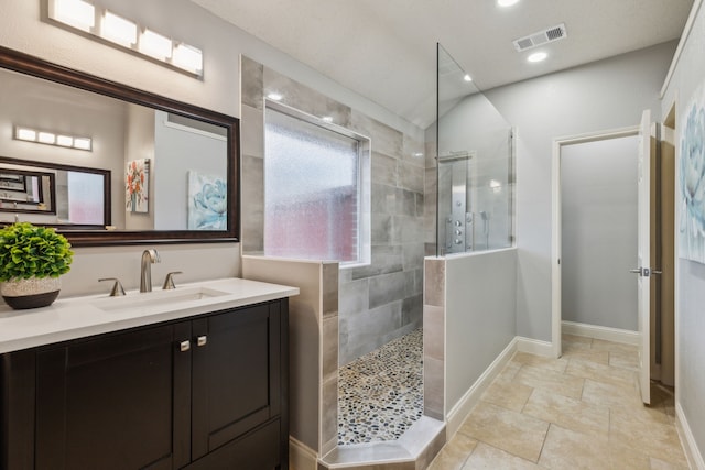 bathroom with vanity and tiled shower