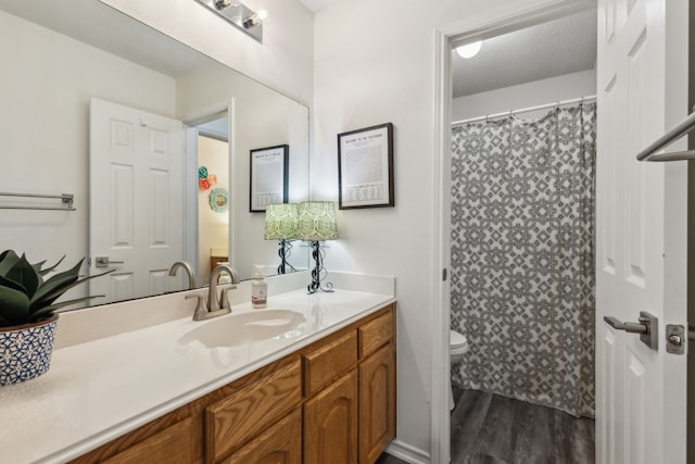 bathroom with vanity, wood-type flooring, and toilet