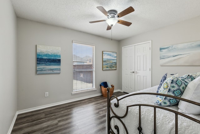 bedroom with ceiling fan, dark hardwood / wood-style flooring, a closet, and a textured ceiling