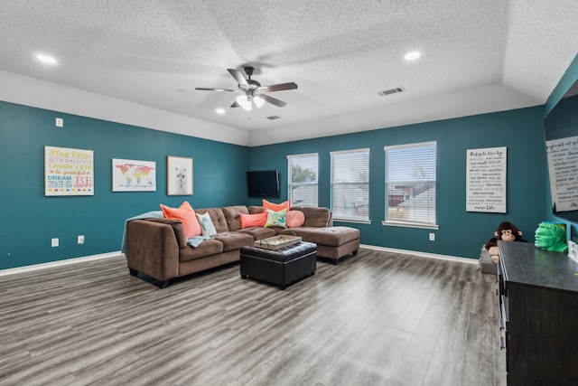 living room featuring hardwood / wood-style flooring, vaulted ceiling, a textured ceiling, and ceiling fan