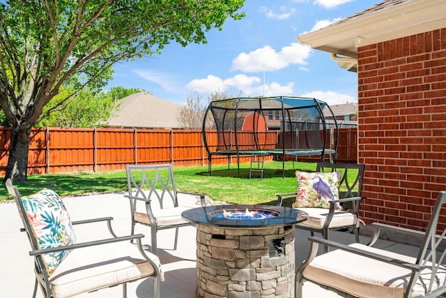 view of patio / terrace featuring an outdoor fire pit and a trampoline