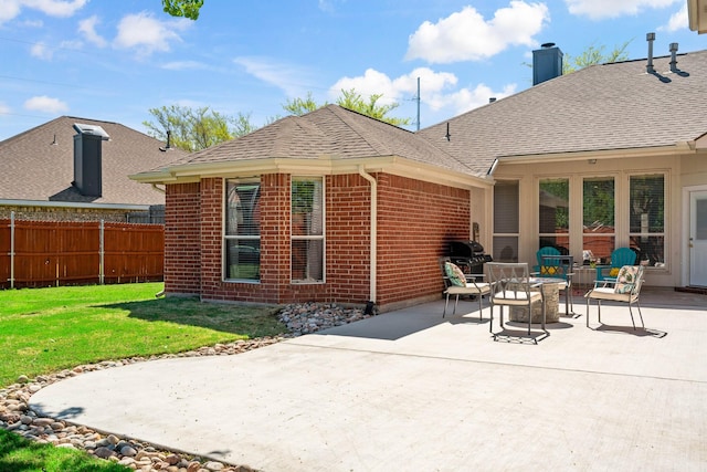 rear view of property with a lawn and a patio