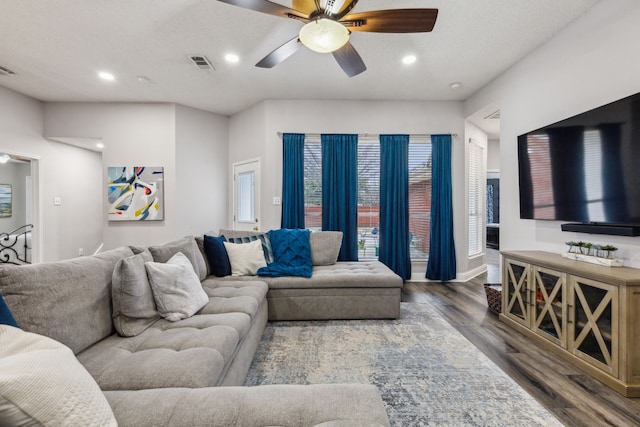 living room with ceiling fan and dark hardwood / wood-style flooring