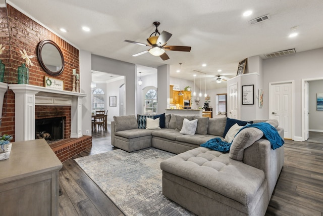 living room featuring a brick fireplace, dark hardwood / wood-style floors, and ceiling fan