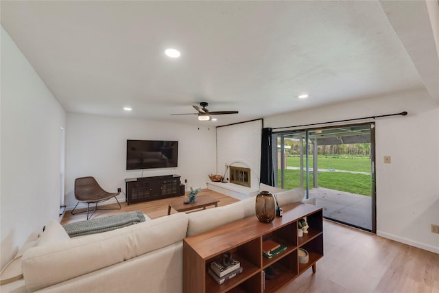 living room with light hardwood / wood-style floors and ceiling fan