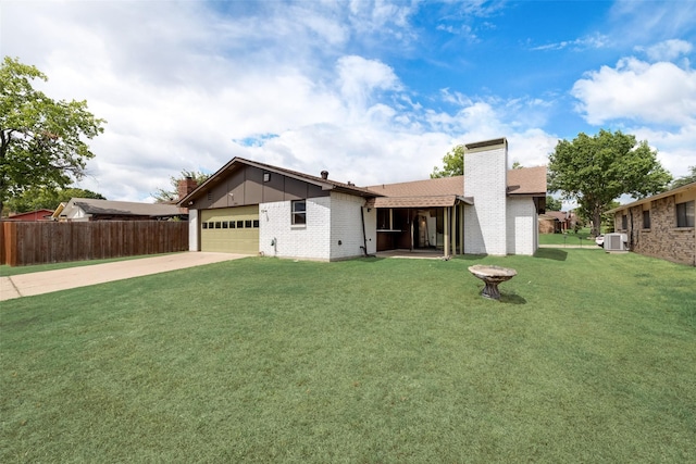 view of front of house featuring a garage, ac unit, and a front yard