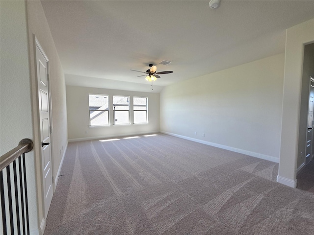 carpeted empty room featuring a ceiling fan and baseboards