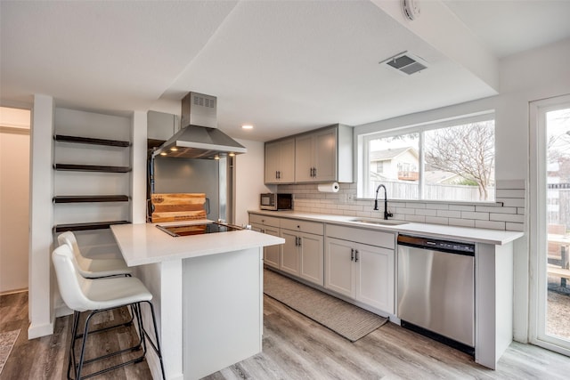 kitchen featuring sink, stainless steel appliances, tasteful backsplash, island range hood, and a kitchen island