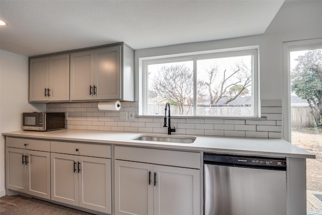 kitchen with gray cabinets, tasteful backsplash, sink, stainless steel appliances, and a textured ceiling