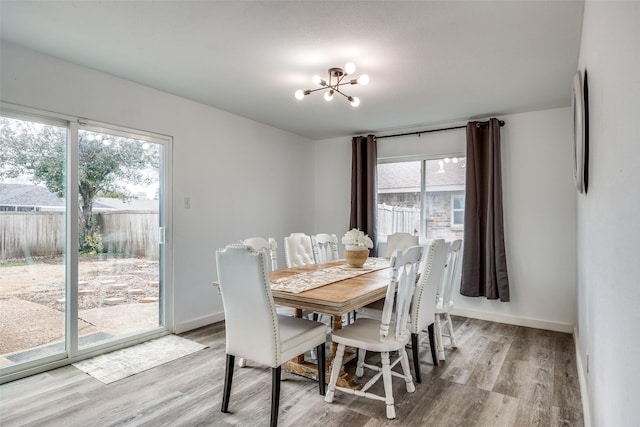 dining space with an inviting chandelier and light hardwood / wood-style floors