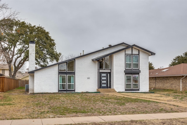 view of front of house with central AC unit and a front lawn