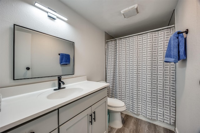 bathroom featuring hardwood / wood-style flooring, vanity, curtained shower, and toilet