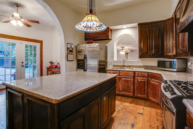 kitchen with premium range hood, sink, a center island, appliances with stainless steel finishes, and light hardwood / wood-style floors