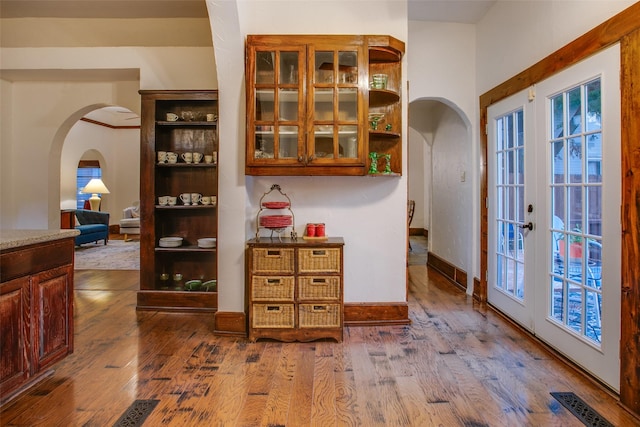 interior space with a healthy amount of sunlight, hardwood / wood-style floors, and french doors