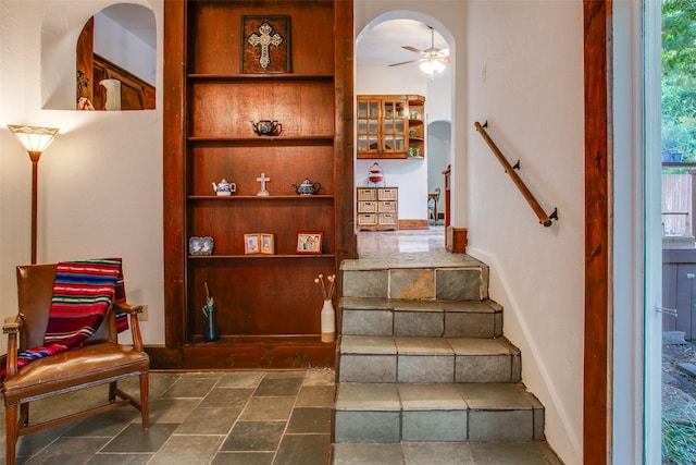 staircase featuring ceiling fan