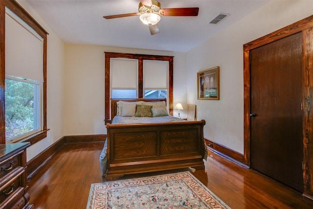 bedroom with dark hardwood / wood-style floors and ceiling fan