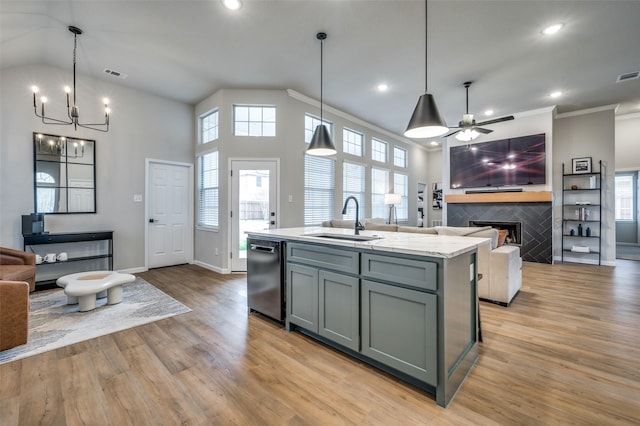 kitchen featuring gray cabinetry, a tile fireplace, a sink, dishwasher, and open floor plan