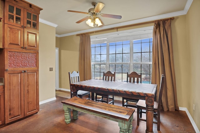 dining space featuring crown molding, concrete floors, ceiling fan, and baseboards