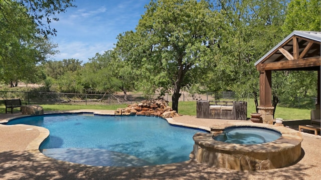 view of pool with a pool with connected hot tub and a fenced backyard