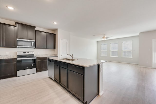 kitchen with light wood finished floors, ceiling fan, a sink, and appliances with stainless steel finishes