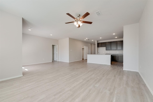 unfurnished living room featuring ceiling fan and light hardwood / wood-style floors