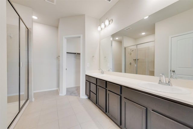 bathroom featuring vanity, a shower with shower door, and tile patterned floors