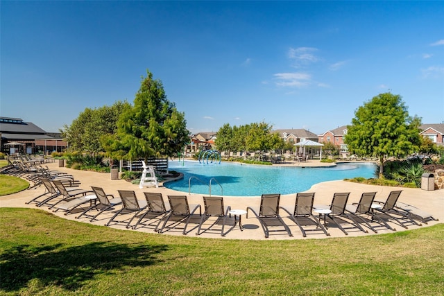 view of swimming pool with a yard, a patio area, and pool water feature