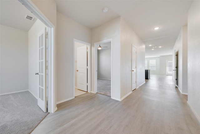 hall with baseboards, light wood finished floors, and recessed lighting