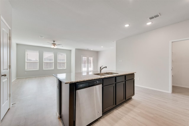 kitchen with light wood finished floors, light stone counters, stainless steel dishwasher, a sink, and open floor plan