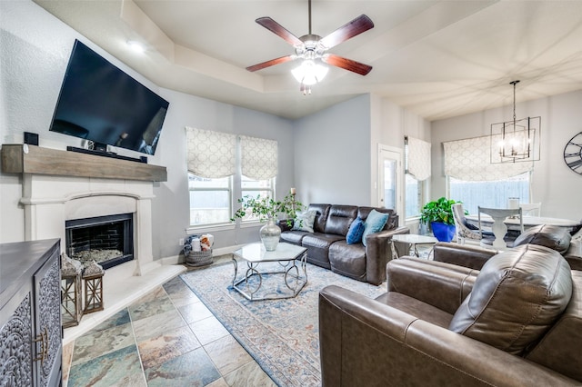 15805 Rockingham St, Frisco, TX 75036 - living area featuring ceiling fan, a chandelier, baseboards, a fireplace with raised hearth, and a raised ceiling