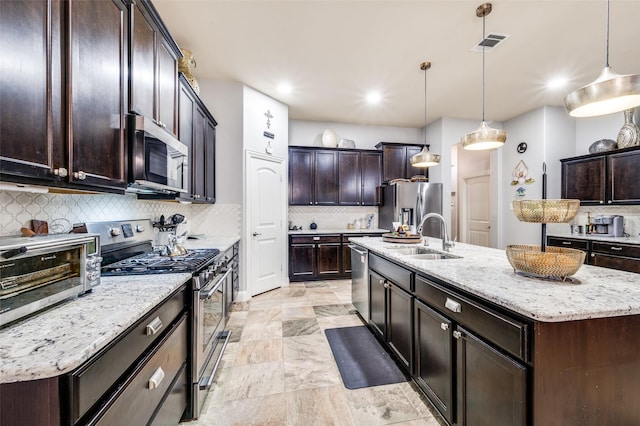 15805 Rockingham St, Frisco, TX 75036 - kitchen featuring appliances with stainless steel finishes, a sink, decorative backsplash, an island with sink, and recessed lighting