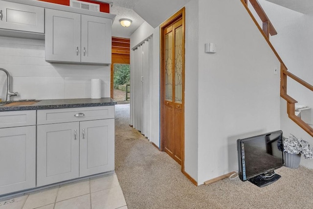 kitchen featuring light carpet and sink