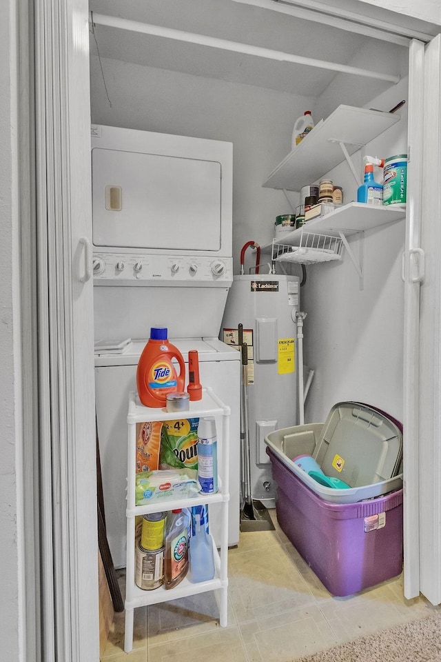 washroom with stacked washer and clothes dryer and electric water heater