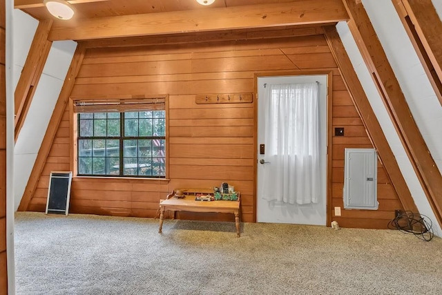 interior space with carpet, vaulted ceiling with beams, electric panel, and wood walls